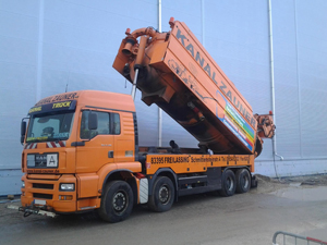 Großer oranger LKW mit aufgestelltem Tank und Werbeaufkleber der Firma Kanal Zauner